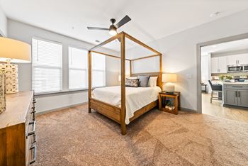 A bedroom with a four poster bed and a ceiling fan.